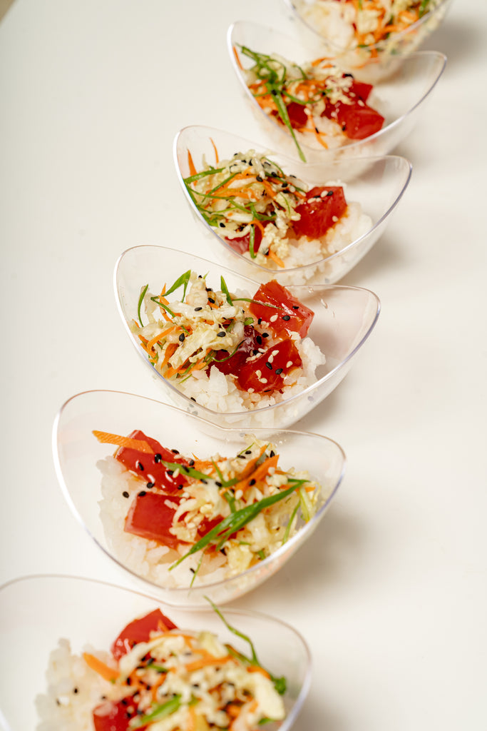 Six Mini Tuna Poke Bowls arranged diagonally, each filled with sushi rice, diced tuna, shredded vegetables, and topped with sesame seeds, green onions, and a citrus lemongrass ponzu drizzle.