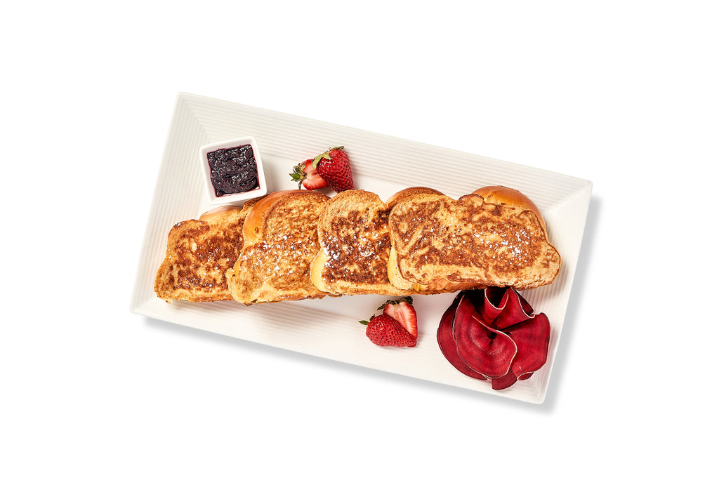 A plate of Brioche French Toast with strawberries and syrup.
