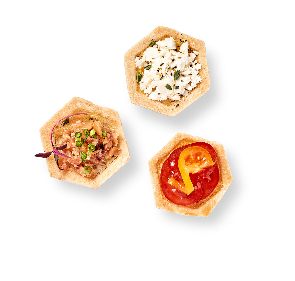Three small Mini Quiches with Vegetable and Lorraine toppings on a white background.
