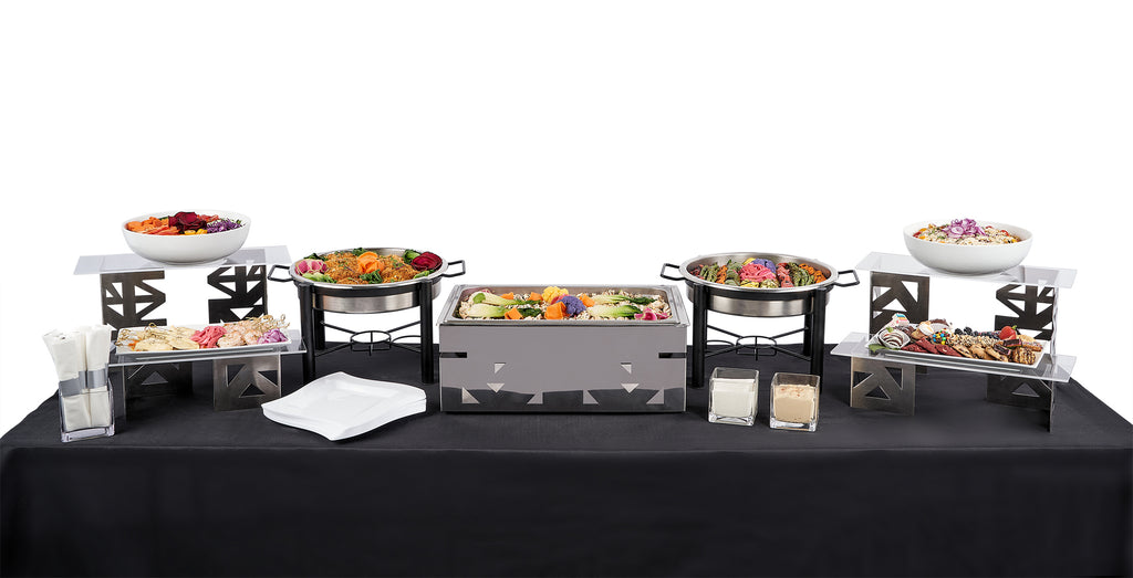 A buffet set up with a Greek Themed Menu table brimming with selections of food in bowls.