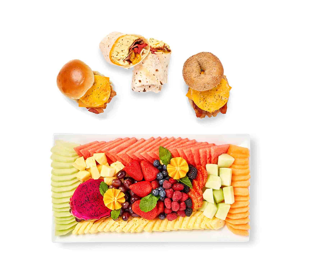 A plate of fruit and Breakfast Sandwich Breakfast Package.