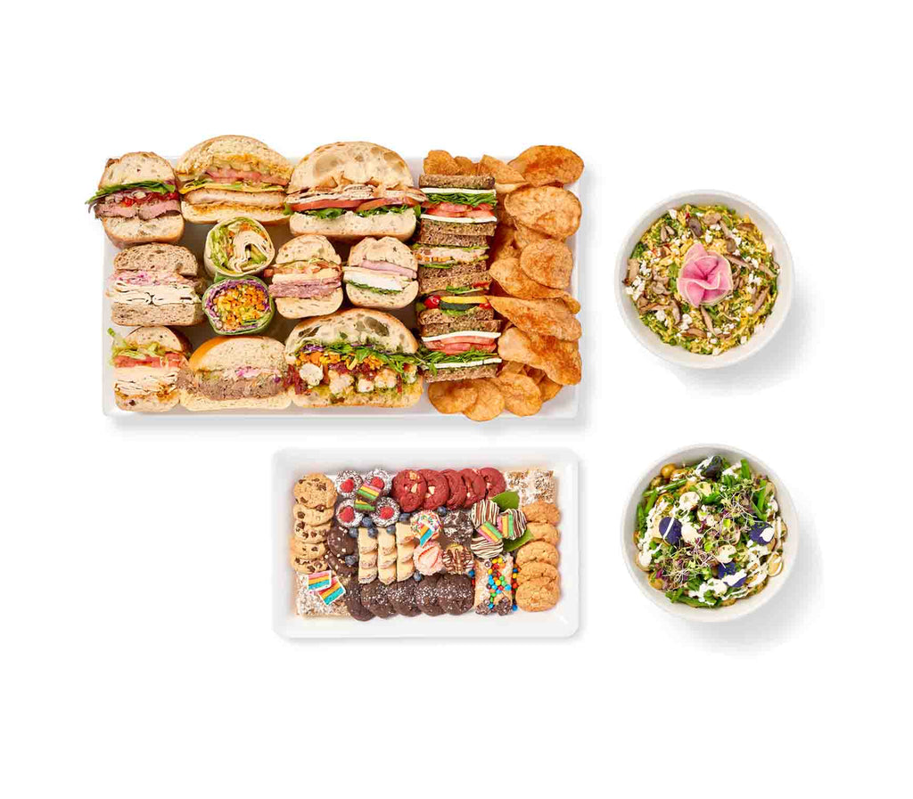 An assortment of Executive Lunch packages featuring assorted sandwiches, wraps, salads, and desserts elegantly presented on trays.
