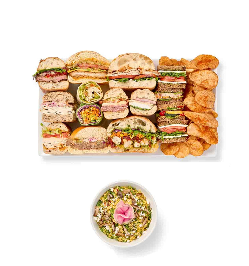 An Express Lunch of assorted sandwiches and wraps with a bowl of dip.