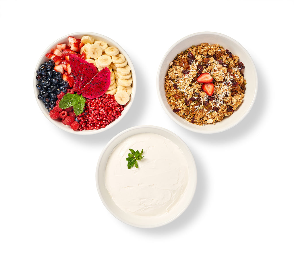Three bowls of DIY Yogurt, Granola and Fruit Bar on a white background.