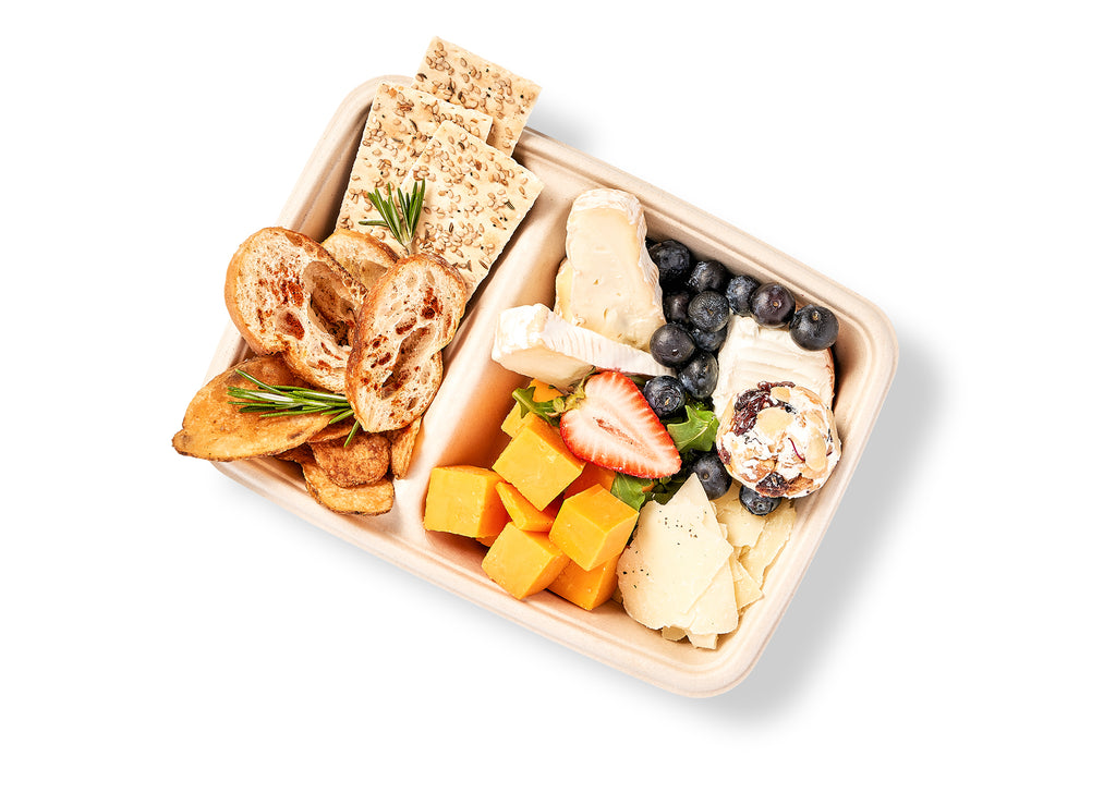A Cheese Board Snack Box with sharp cheddar cheese, crackers, and fruit.