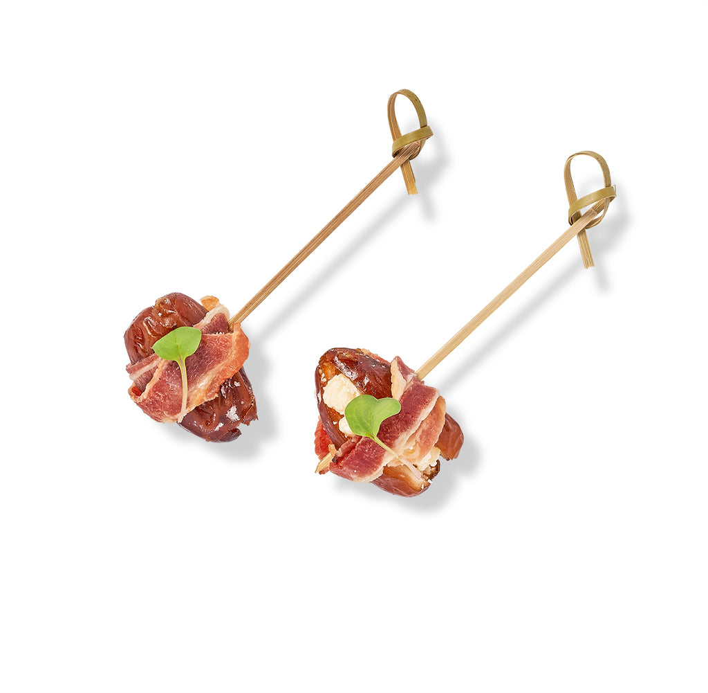 Two skewers with Bacon Wrapped Dates and bleu cheese mousse on them.