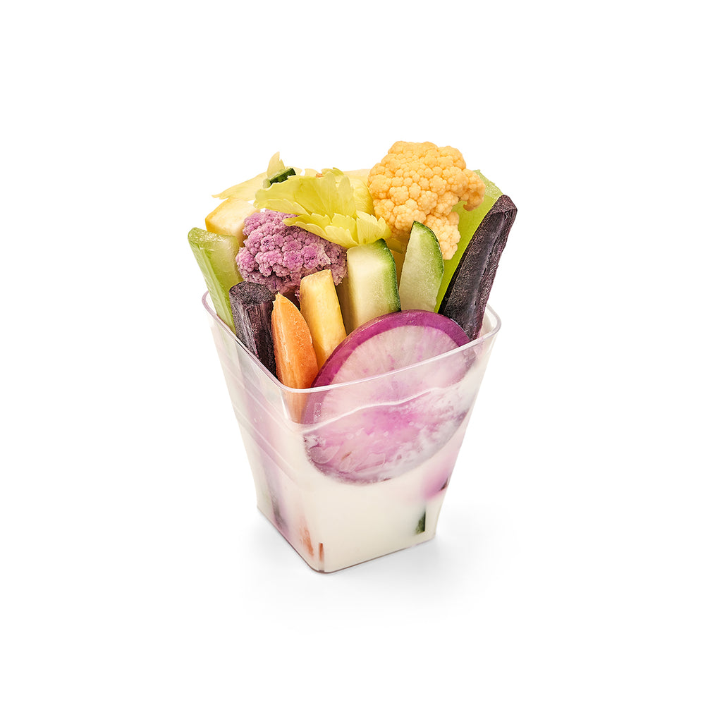 A plastic cup filled with Individual Crudité Shooters.