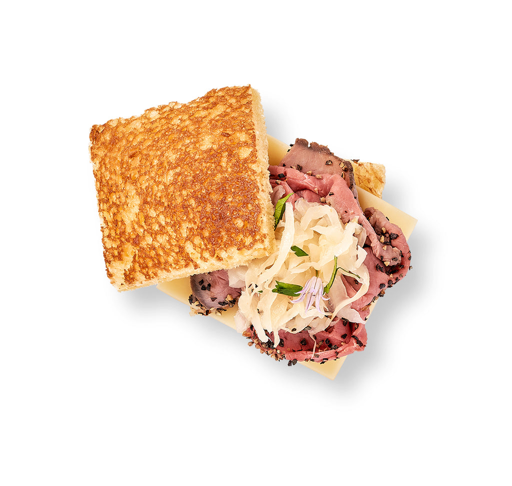 A tender Mini Reuben sandwich with Swiss cheese on a white background.