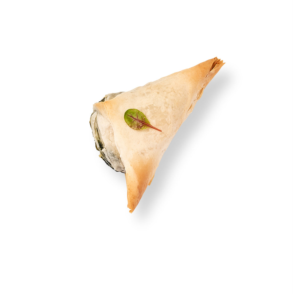 Spanakopita triangles filled with spinach and feta cheese on a white background.