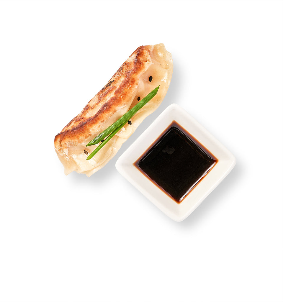 Chinese Potstickers accompanied by soy sauce.