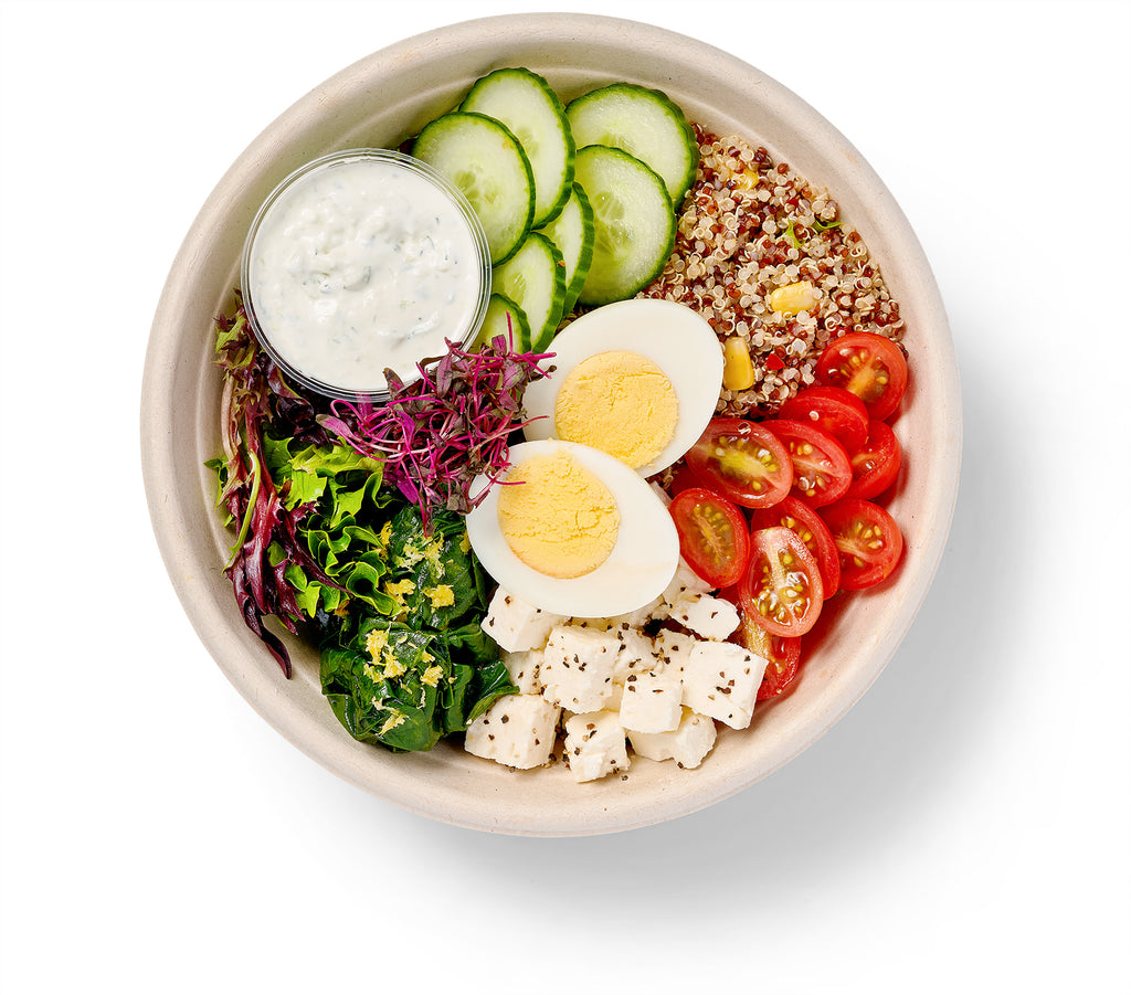 A Mediterranean Breakfast Bowl filled with vegetables, hard-boiled eggs, and hummus.