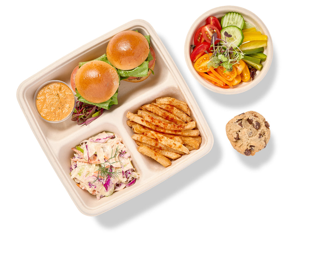 An american theme bento box with hamburgers  Accompanied by Shoestring Fries with Chipotle Mayo, Apple-Cabbage Slaw, Tossed Salad with a Citrus Vinaigrette and a Homemade Cookie
