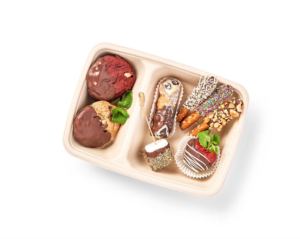 A tray filled with mouthwatering Chocolate Lovers Snack Boxes, including chocolate covered strawberries and chocolate dipped pretzels, set against a clean white background.