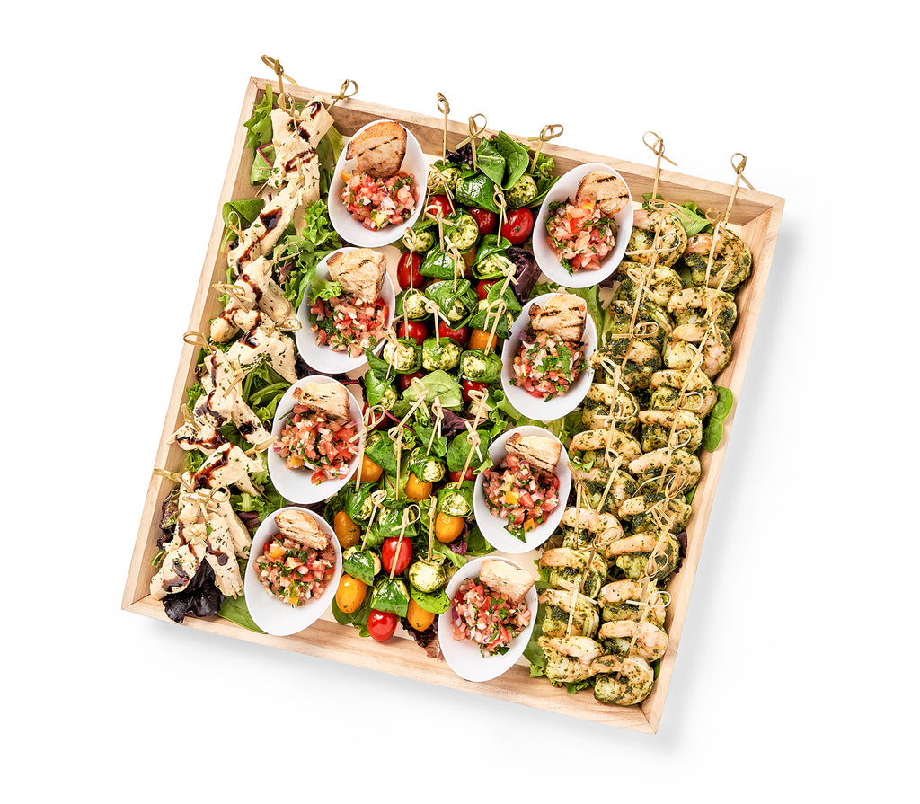 A Tuscany Party Platter with a variety of appetizers on it, including Balsamic Chicken Skewers and Baby Mozzarella & Tomatoes.