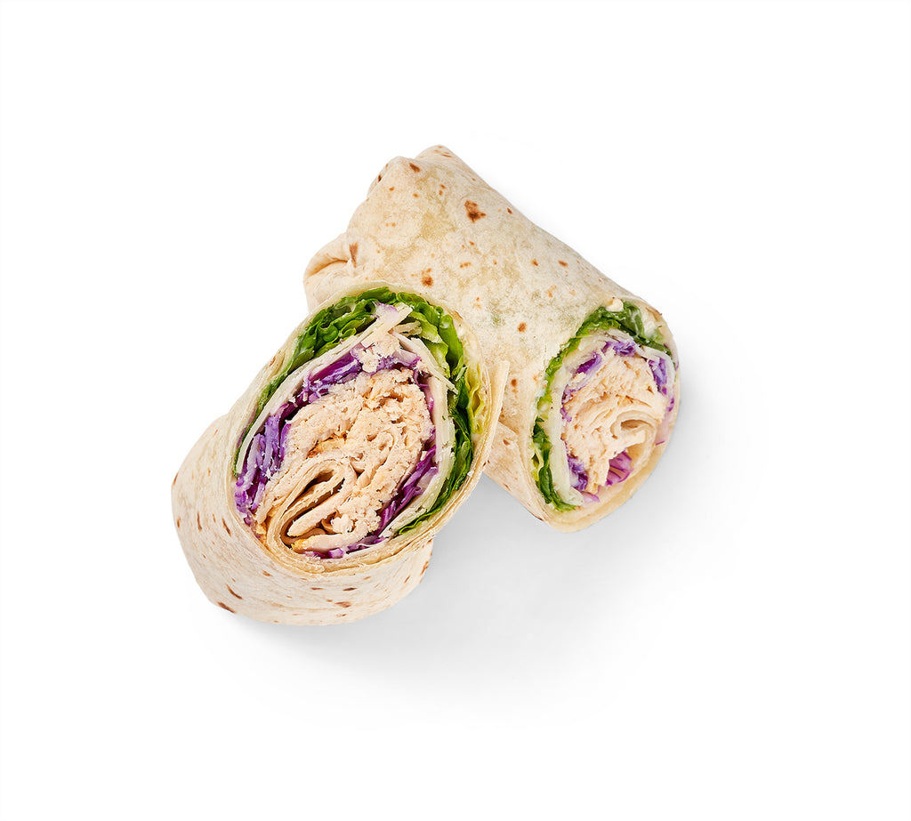 Two Chicken Caesar Wraps with lettuce and Caesar dressing on a white background.