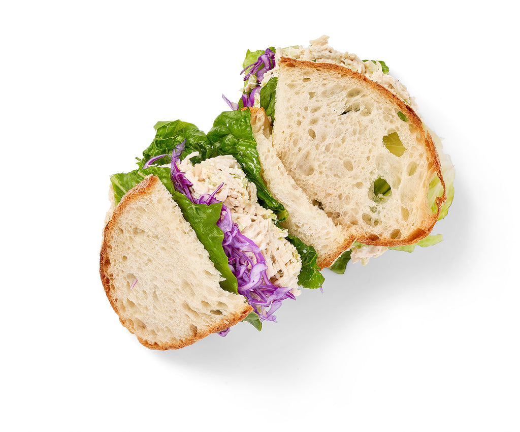 A classic Chicken Salad Sandwich with slaw on a white background.