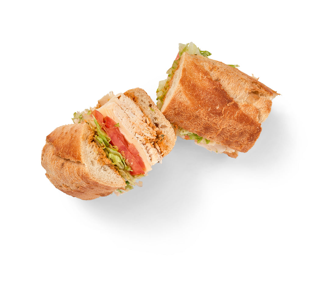 Two Grilled Chicken Sandwiches with Provolone, cut in half on a white background.