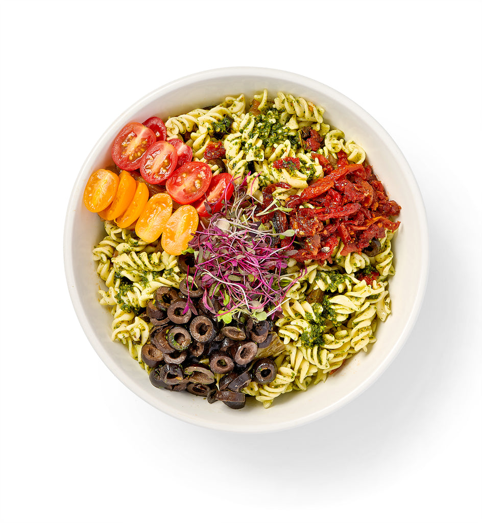 A bowl of Fusilli Pasta Salad with tomatoes, black olives, and other vegetables.