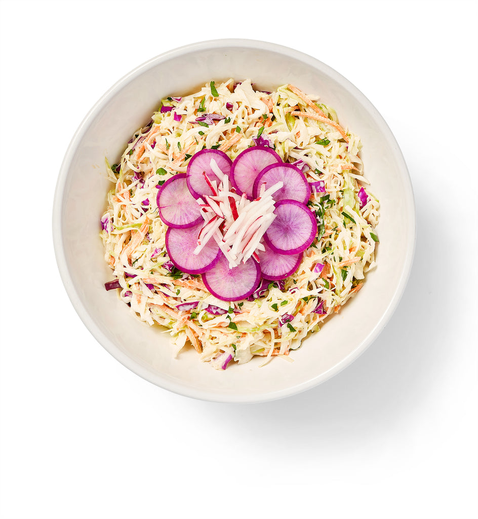 A bowl of Asian Sesame Salad with Napa cabbage and radishes in it.