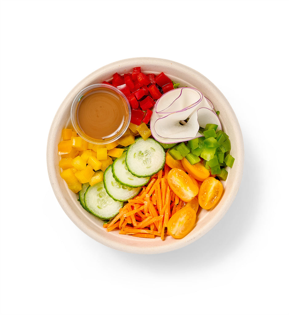 A Tossed Individual Entree Salad filled with carrots and baby field greens, served with a dipping sauce.