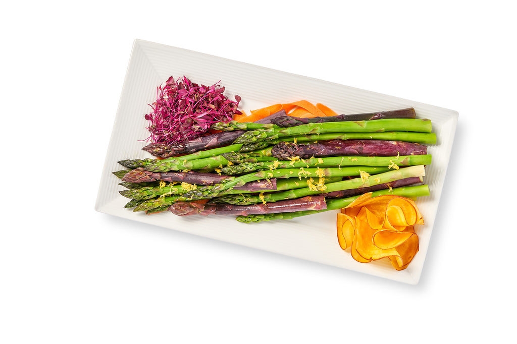 A white plate with Lemon Grilled Asparagus, carrots and red cabbage.